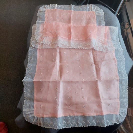 This is a 2 piece vintage pink bassinet, crib, or pram coverlet and sham with embroidered flowers.
This pink bassinet coverlet and sham are trimmed with sheer machine embroidered lace trim.
This bassinet,crib or pram coverlet has a sheer polyester layer on top that is embroidered with blue and pink flowers and a non-sheer polyester layer underneath.