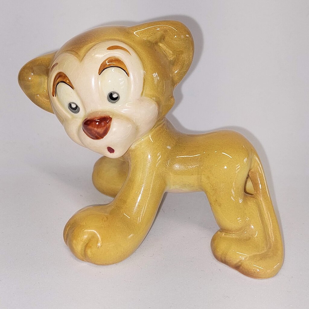 This is a David Hand's ZIMMY LION 1150 of Animaland Series by Beswick England. 1949-1955
The ZIMMY LION figurine is one of eight characters in David Hand's Animaland character series.
The figurine is 3-1/4 inches (8.25cm) tall.  
The backstamp is gold and reads: David Hand's Animaland, "Zimmy Lion 1150" Beswick England 6, Copyright by GB Animations Ltd.
