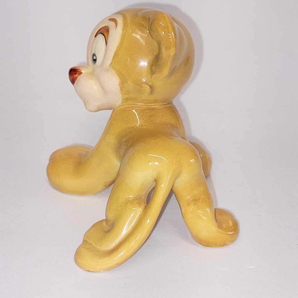 This is a David Hand's ZIMMY LION 1150 of Animaland Series by Beswick England. 1949-1955
The ZIMMY LION figurine is one of eight characters in David Hand's Animaland character series.
The figurine is 3-1/4 inches (8.25cm) tall.  
The backstamp is gold and reads: David Hand's Animaland, "Zimmy Lion 1150" Beswick England 6, Copyright by GB Animations Ltd.