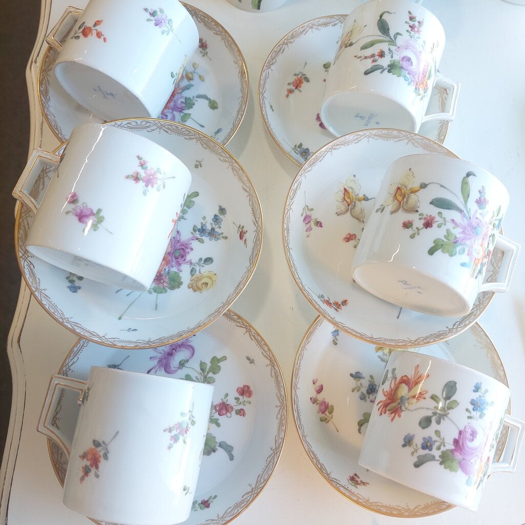 This is a 12 piece Meissen Dresden set of 6 Coupe Plates and 6 Coffee can cups in the Floral Sprays pattern.
There are 6 coffee cans and 6 coupe shaped dessert or fruit plates.
The dishes are hand painted with the Floral Sprays pattern with a large spray and individual flower sprays around it. The rim is decorated in a drape pattern in gold. Each can cup has a single flower painted in the bottom.