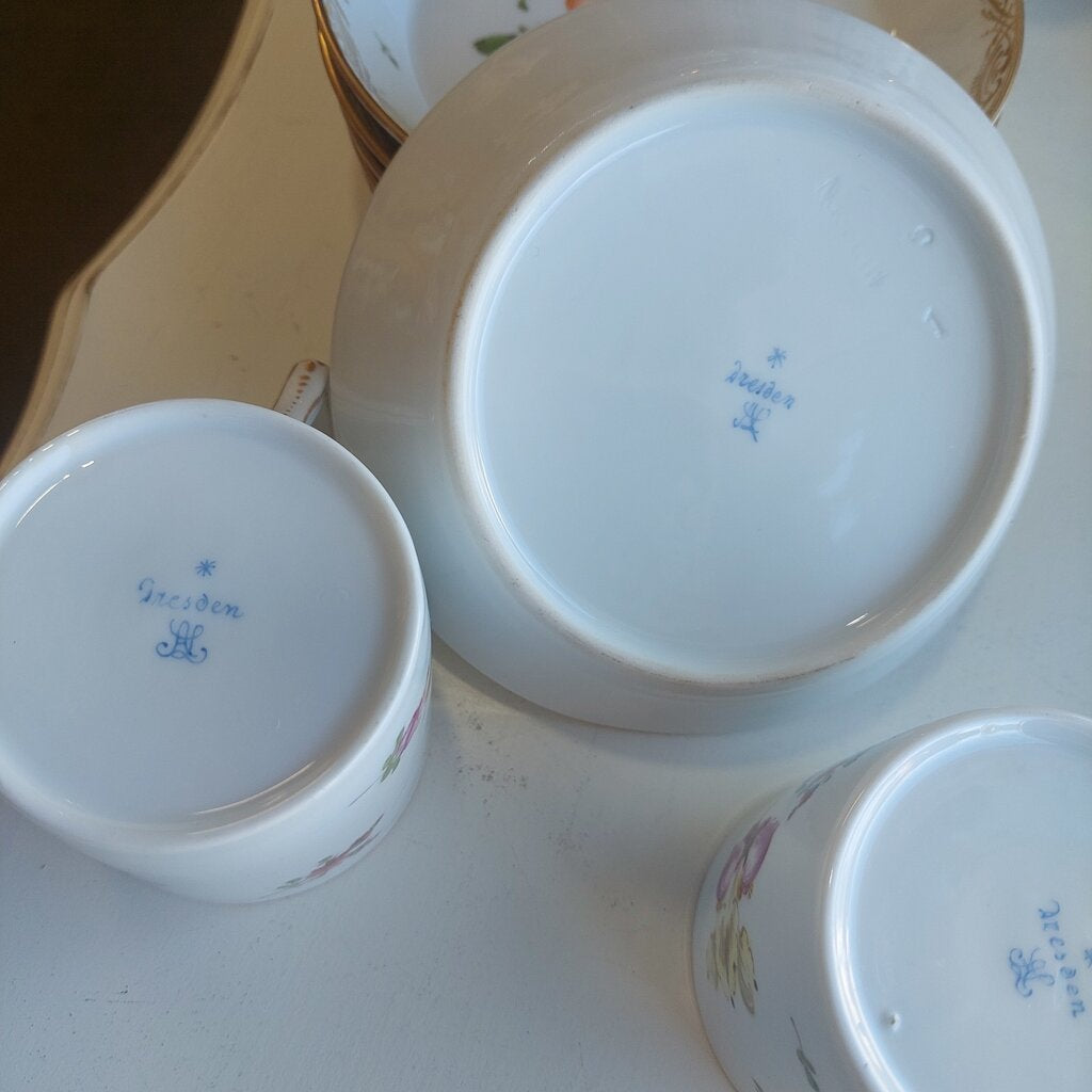 This is a 12 piece Meissen Dresden set of 6 Coupe Plates and 6 Coffee can cups in the Floral Sprays pattern.
There are 6 coffee cans and 6 coupe shaped dessert or fruit plates.
The dishes are hand painted with the Floral Sprays pattern with a large spray and individual flower sprays around it. The rim is decorated in a drape pattern in gold. Each can cup has a single flower painted in the bottom.