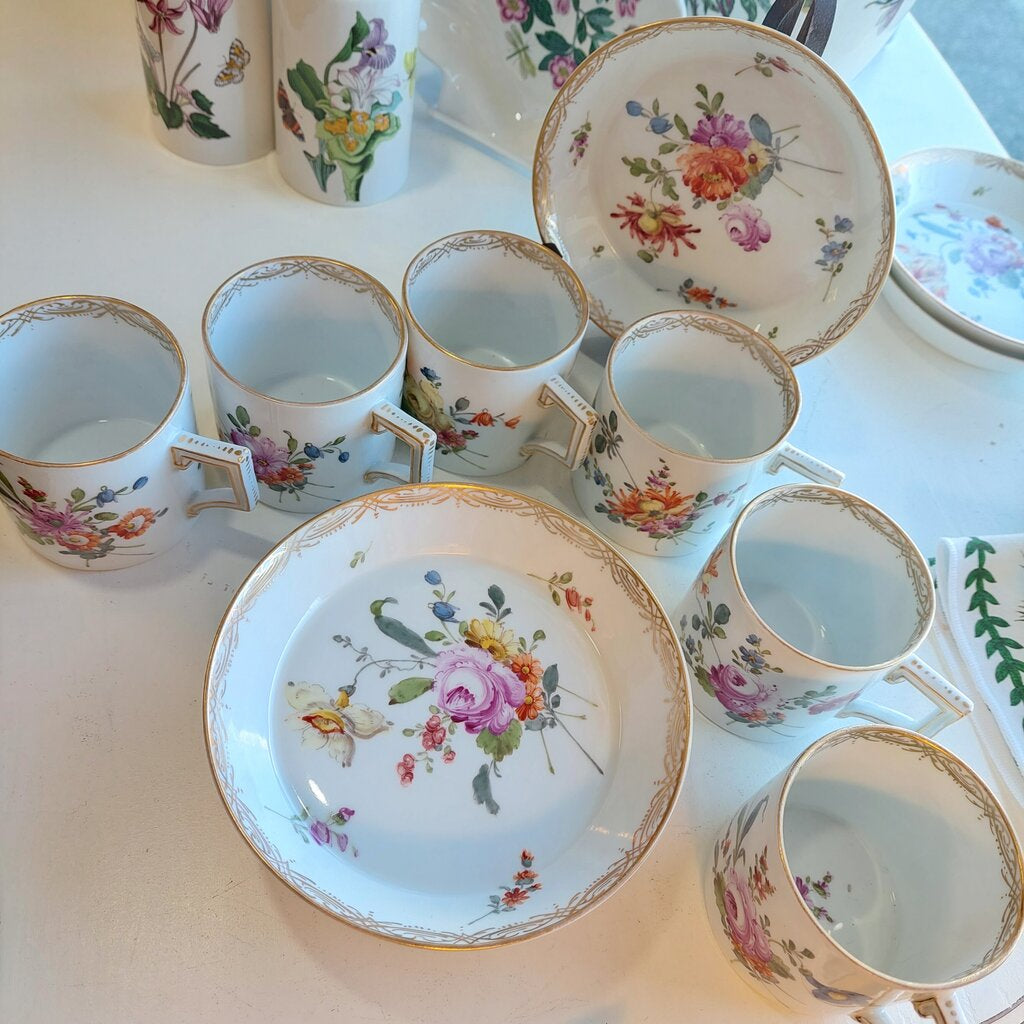 This is a 12 piece Meissen Dresden set of 6 Coupe Plates and 6 Coffee can cups in the Floral Sprays pattern.
There are 6 coffee cans and 6 coupe shaped dessert or fruit plates.
The dishes are hand painted with the Floral Sprays pattern with a large spray and individual flower sprays around it. The rim is decorated in a drape pattern in gold. Each can cup has a single flower painted in the bottom.