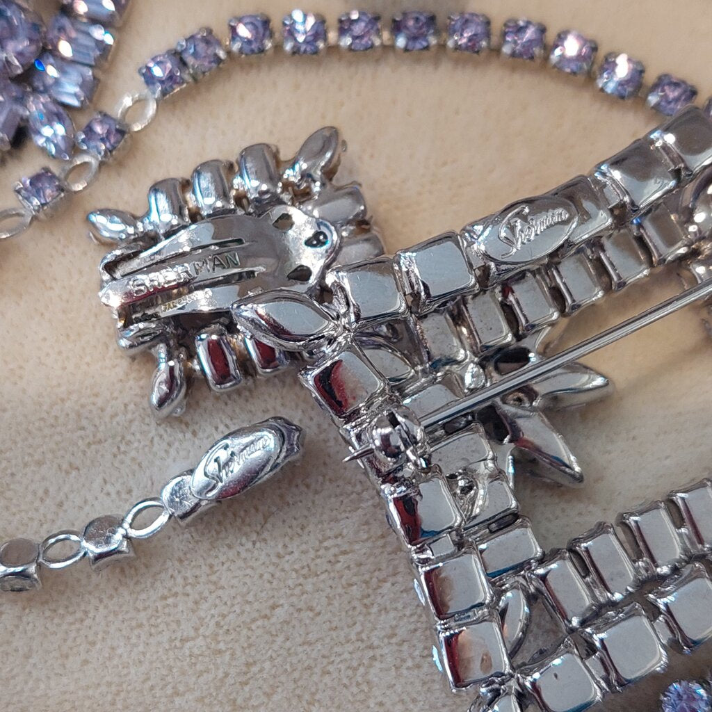 This is a rare vintage 1950s Sherman necklace, clip on earrings, and brooch set in an amazing mauve colour. The crystals are a unique mix of baguette, marquise, round, and teardrop cuts. The 4 piece set comes in their original hinged box.