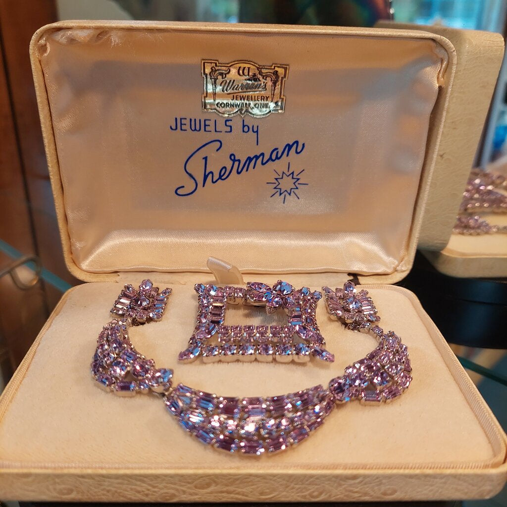 This is a rare vintage 1950s Sherman necklace, clip on earrings, and brooch set in an amazing mauve colour. The crystals are a unique mix of baguette, marquise, round, and teardrop cuts. The 4 piece set comes in their original hinged box.
