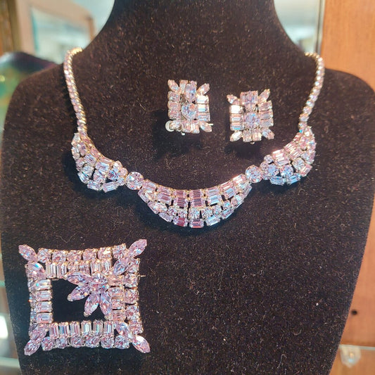 This is a rare vintage 1950s Sherman necklace, clip on earrings, and brooch set in an amazing mauve colour. The crystals are a unique mix of baguette, marquise, round, and teardrop cuts. The 4 piece set comes in their original hinged box.