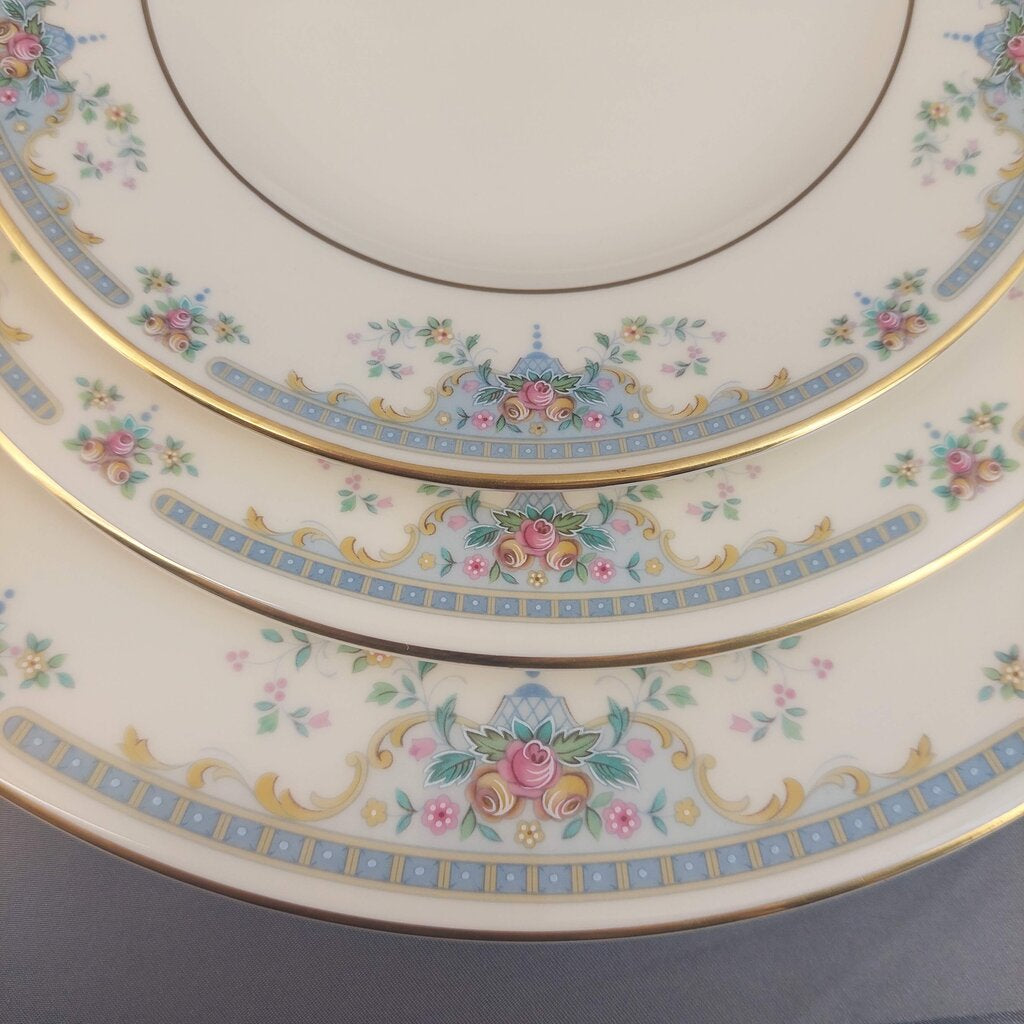 Set of three decorative plates with floral and gold patterns on a gray background