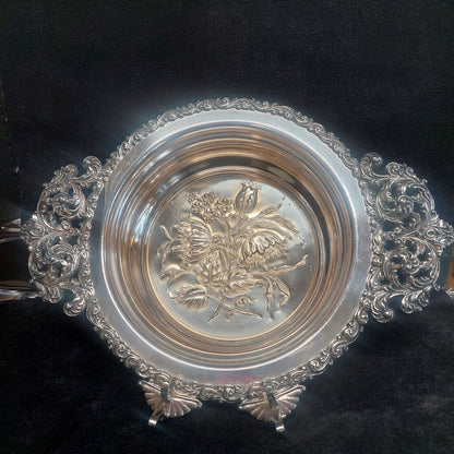 Decorative silver bowl with intricate designs on a black background
