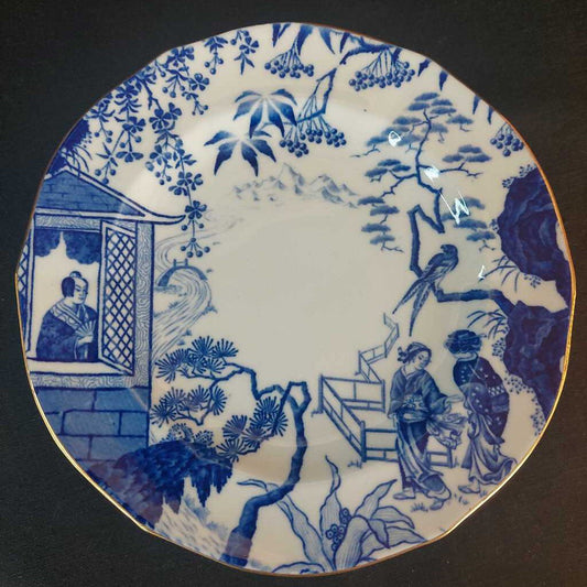 Blue and white ceramic plate with traditional design of people and nature